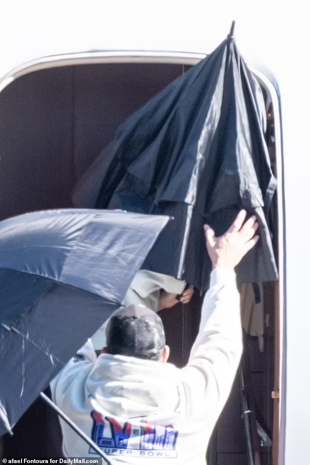 Taylor Swift under umbrella leaving Las Vegas